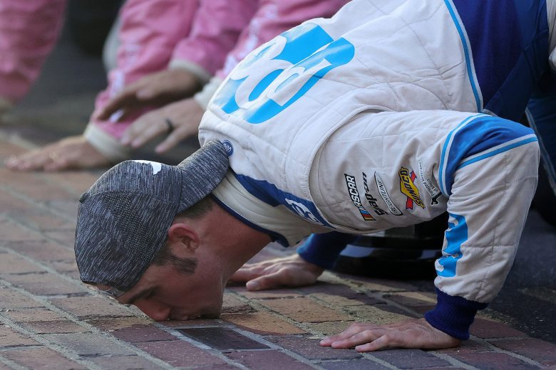 INDIANAPOLIS, INDIANA - AUGUST 14: Austin Cindric, driver of the #22 PPG Ford, celebrate by kissing the bricks after winning the NASCAR Xfinity Series Pennzoil 150 at the Brickyard at Indianapolis Motor Speedway on August 14, 2021 in Indianapolis, Indiana. (Photo by Stacy Revere/Getty Images) | Getty Images