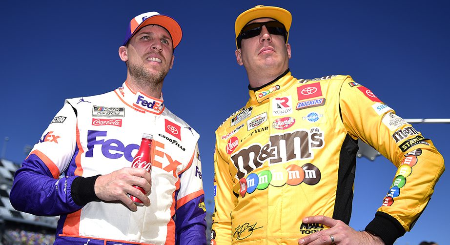 Teammates Denny Hamlin and Kyle Busch stand on the grid together.