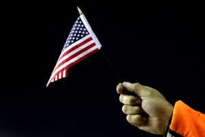 RICHMOND, VA - SEPTEMBER 10: A crew member for Jamie McMurray, driver of the #1 Bass Pro Shops/Tracker Chevrolet, holds an American flag in tribute to the lives lost in the terrorist attacks of September 11, 2001 during the NASCAR Sprint Cup Series Wonderful Pistachios 400 at Richmond International Raceway on September 10, 2011 in Richmond, Virginia. (Photo by Jerry Markland/Getty Images for NASCAR) | Getty Images