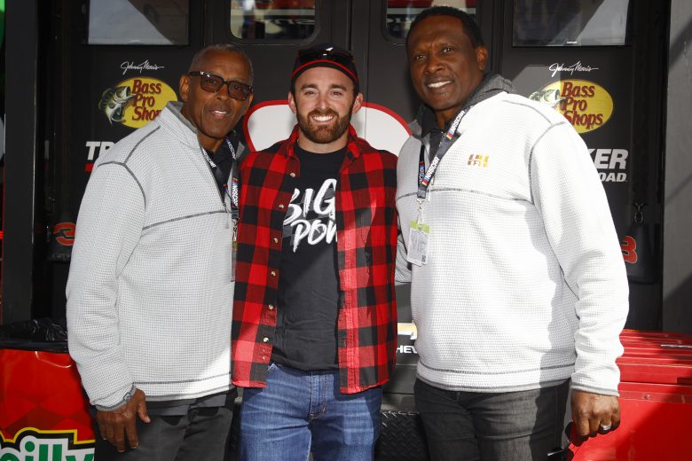 FORT WORTH, TEXAS - OCTOBER 17: Austin Dillon, driver of the #3 Bass Pro Shops/Tracker Off Road Chevrolet, (C) poses for photos with NFL Hall of Famers Tony Dorsett (L) and Tim Brown prior to the NASCAR Cup Series Autotrader EchoPark Automotive 500 at Texas Motor Speedway on October 17, 2021 in Fort Worth, Texas. (Photo by Chris Graythen/Getty Images) | Getty Images
