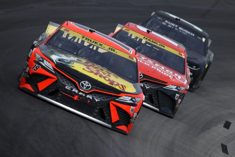 FORT WORTH, TEXAS - OCTOBER 17: Martin Truex Jr., driver of the #19 Bass Pro Shops Toyota, Denny Hamlin, driver of the #11 Craftsman Toyota, and Kurt Busch, driver of the #1 Monster Energy Chevrolet, race during the NASCAR Cup Series Autotrader EchoPark Automotive 500 at Texas Motor Speedway on October 17, 2021 in Fort Worth, Texas. (Photo by Sean Gardner/Getty Images) | Getty Images