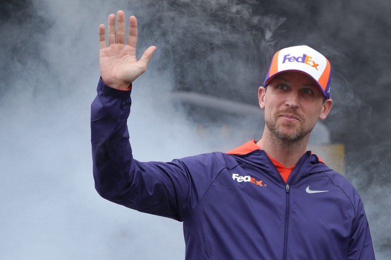 TALLADEGA, ALABAMA - OCTOBER 03: Denny Hamlin, driver of the #11 FedEx Express Toyota, waves to fans as he walks on stage during pre-race ceremonies prior to the NASCAR Cup Series YellaWood 500 at Talladega Superspeedway on October 03, 2021 in Talladega, Alabama. (Photo by Sean Gardner/Getty Images) | Getty Images