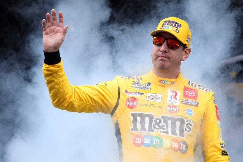 TALLADEGA, ALABAMA - OCTOBER 03: Kyle Busch, driver of the #18 M&M's Toyota, waves to fans as he walks on stage during pre-race ceremonies prior to the NASCAR Cup Series YellaWood 500 at Talladega Superspeedway on October 03, 2021 in Talladega, Alabama. (Photo by Sean Gardner/Getty Images) | Getty Images