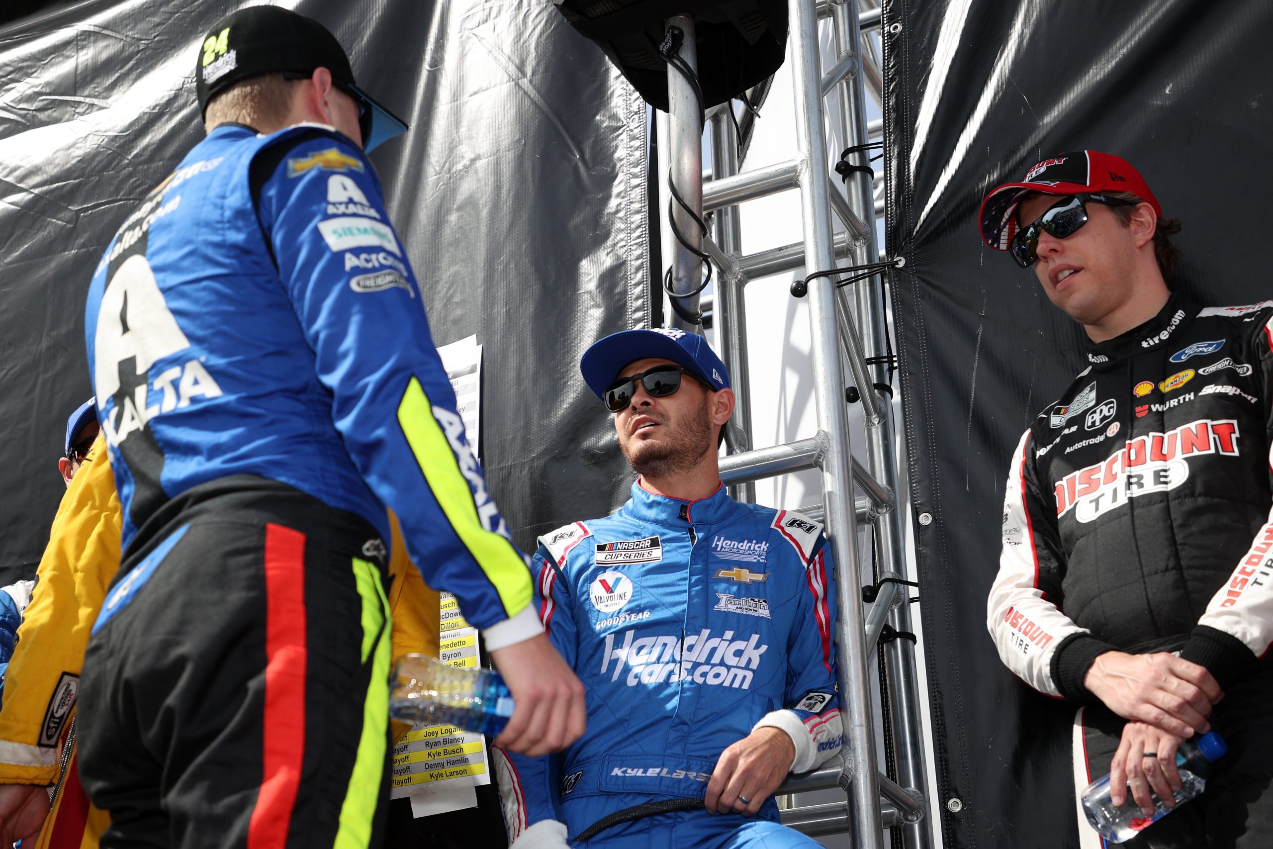 FORT WORTH, TEXAS - OCTOBER 17: Kyle Larson, driver of the #5 HendrickCars.com Chevrolet, Brad Keselowski, driver of the #2 Discount Tire Ford, and William Byron, driver of the #24 Axalta Chevrolet, talk backstage during pre-race ceremonies prior to the NASCAR Cup Series Autotrader EchoPark Automotive 500 at Texas Motor Speedway on October 17, 2021 in Fort Worth, Texas. (Photo by Chris Graythen/Getty Images) | Getty Images