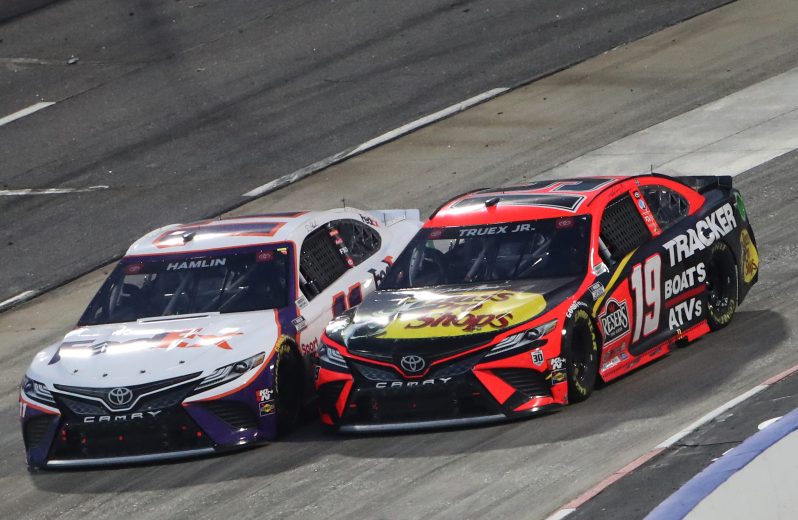 MARTINSVILLE, VIRGINIA - APRIL 11: Denny Hamlin, driver of the #11 FedEx Office Toyota, and Martin Truex Jr., driver of the #19 Bass Pro Toyota, race during the NASCAR Cup Series Blue-Emu Maximum Pain Relief 500 at Martinsville Speedway on April 11, 2021 in Martinsville, Virginia. (Photo by James Gilbert/Getty Images) | Getty Images