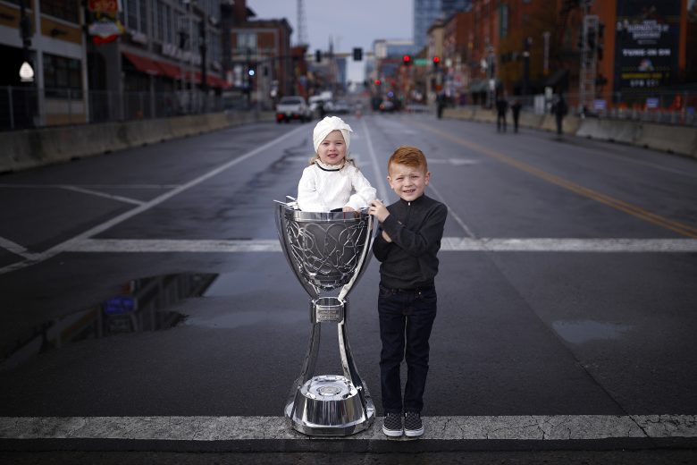 NASHVILLE, TENNESSEE - DECEMBER 01: Owen and Audrey Larson, the children of 2021 NASCAR Cup Series championship driver, Kyle Larson (not pictured) pose wi the Bill France 2021 NASCAR Cup Series Championship trophy on Broadway December 01, 2021 in Nashville, Tennessee. (Photo by Jared C. Tilton/Getty Images) | Getty Images