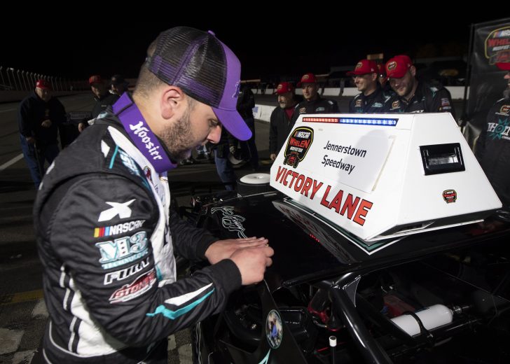 Justin Bonsignore, driver of the #51 Phoenix Communications Inc. Chevrolet, places a winner's decal on his car in victory lane after winning the Jennerstown Salutes 150 Presented By DGV for the NASCAR Whelen Modified Tour in Jennerstown, Pennsylvania on May 29, 2021. (Nate Smallwood/NASCAR)