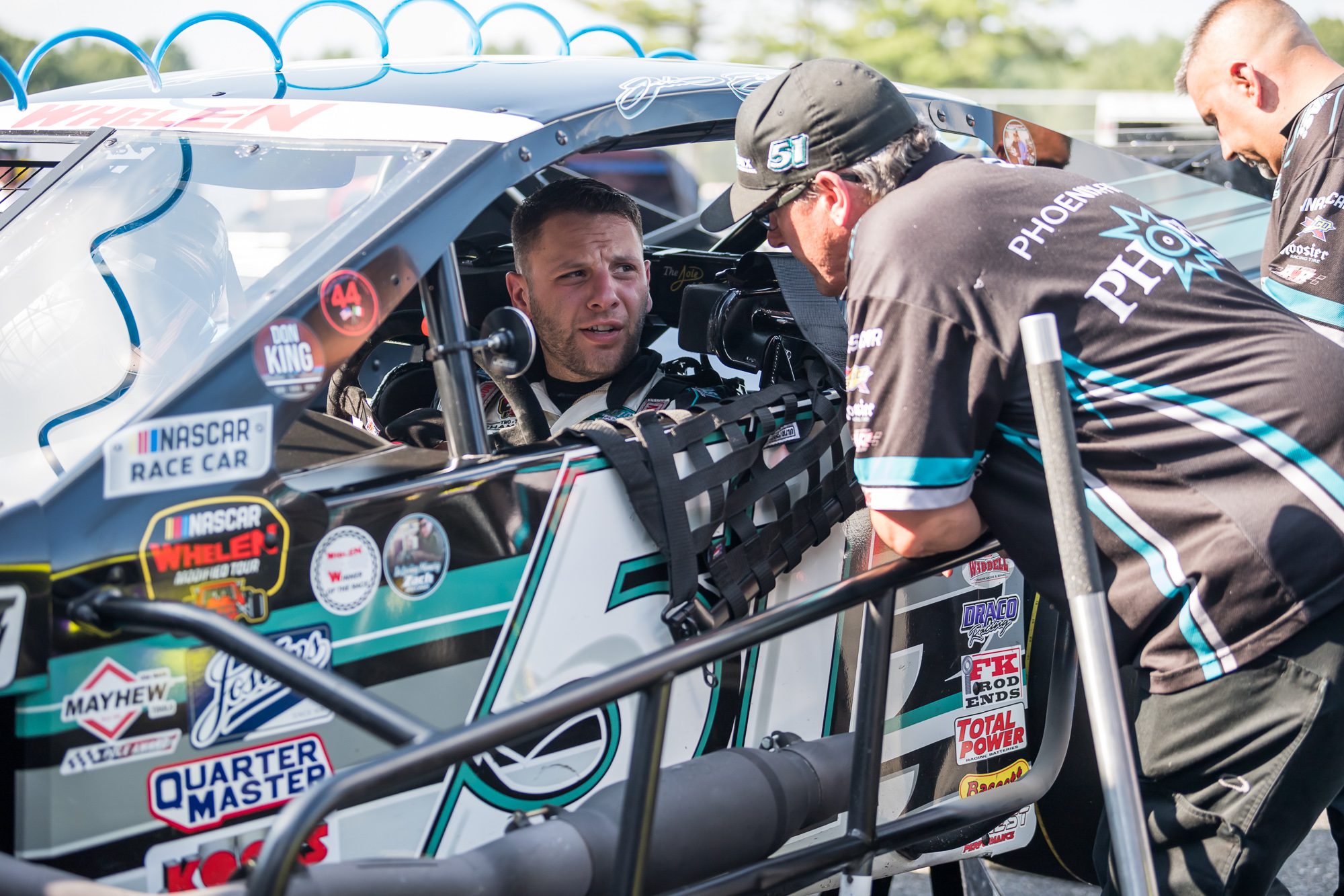 Justin Bonsignore, driver of the #51 Phoenix Communications Inc. Chevrolet, talks with a member of his crew during practice before the GAF Roofing 150 presented by Riverhead Building Supply for the NASCAR Whelen Modified Tour at Stafford Motor Speedway in Stafford Springs, Connecticut on August 6, 2021. (Adam Richins/NASCAR)