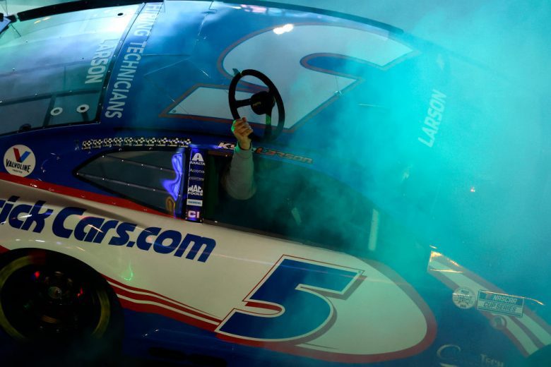 NASHVILLE, TENNESSEE - DECEMBER 01:  Kyle Larson, driver of the #5 NASCAR Cup Series Chevrolet performs a burnout as his father, Mike Larson, from the passenger seat displays the steering wheel during the Burnouts on Broadway December 01, 2021 in Nashville, Tennessee. (Photo by Brett Carlsen/Getty Images) | Getty Images