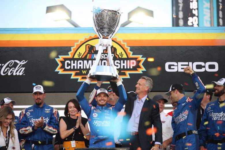 AVONDALE, ARIZONA - NOVEMBER 07: Kyle Larson, driver of the #5 HendrickCars.com Chevrolet, is presented the Bill France 2021 NASCAR Cup Series Championship trophy by NASCAR President Steve Phelps in victory lane after winning the NASCAR Cup Series Championship at Phoenix Raceway on November 07, 2021 in Avondale, Arizona. (Photo by Chris Graythen/Getty Images) | Getty Images