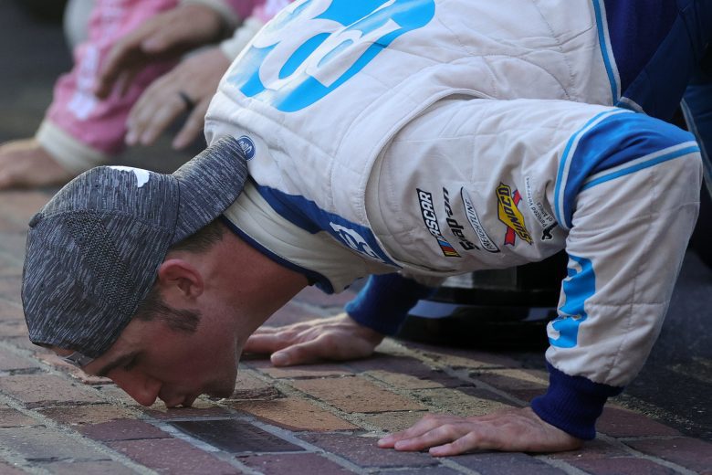 INDIANAPOLIS, INDIANA - AUGUST 14: Austin Cindric, driver of the #22 PPG Ford, celebrate by kissing the yard of bricks after winning the NASCAR Xfinity Series Pennzoil 150 at the Brickyard at Indianapolis Motor Speedway on August 14, 2021 in Indianapolis, Indiana. (Photo by Stacy Revere/Getty Images) | Getty Images