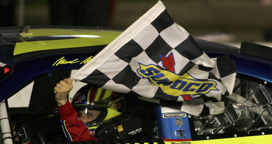 Mark Martin holds the checkered flag outside his car.