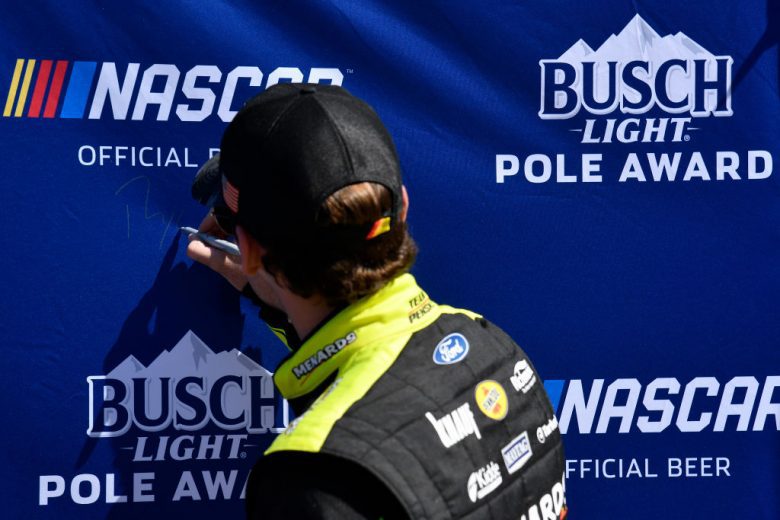 AVONDALE, ARIZONA - MARCH 12: Ryan Blaney, driver of the #12 Menards/Maytag Ford, signs the Busch Light Pole Award backdrop after winning the pole award during qualifying for the Ruoff Mortgage 500 at Phoenix Raceway on March 12, 2022 in Avondale, Arizona. (Photo by Logan Riely/Getty Images) | Getty Images