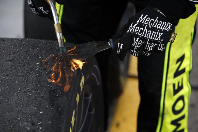 AVONDALE, ARIZONA - MARCH 13: A crew member burns debris off a tire during the the Ruoff Mortgage 500 at Phoenix Raceway on March 13, 2022 in Avondale, Arizona. (Photo by Sean Gardner/Getty Images) | Getty Images