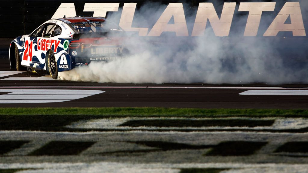 HAMPTON, GEORGIA - MARCH 20: William Byron, driver of the #24 Liberty University Chevrolet, celebrates with a burnout after winning  the NASCAR Cup Series Folds of Honor QuikTrip 500 at Atlanta Motor Speedway on March 20, 2022 in Hampton, Georgia. (Photo by Sean Gardner/Getty Images) | Getty Images
