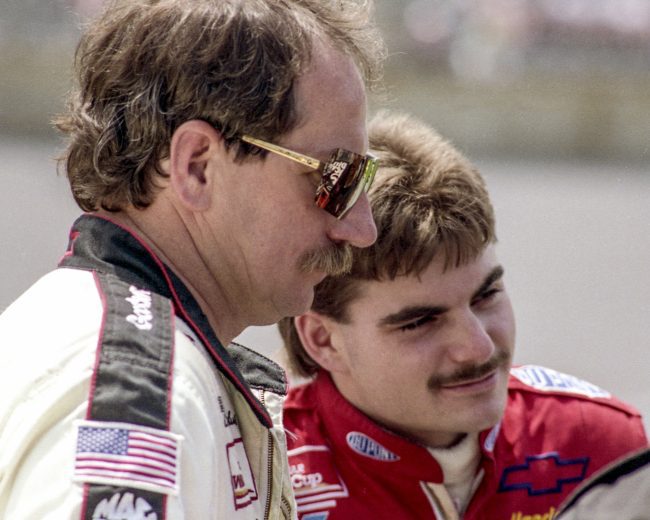 DAYTONA BEACH, FL - JULY 1993: Jeff Gordon (L) in the rookie year of his NASCAR career, talks with Dale Earnhardt Sr. at Daytona International Speedway circa July 1993 in Daytona Beach, Florida. (Photo by Brian Cleary/Getty Images)