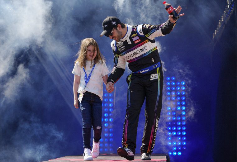 RICHMOND, VIRGINIA - APRIL 03: Daniel Suarez, driver of the #99 CommScope Chevrolet, and guest walk onstage during driver intros prior to the NASCAR Cup Series Toyota Owners 400 at Richmond Raceway on April 03, 2022 in Richmond, Virginia. (Photo by Jacob Kupferman/Getty Images) | Getty Images