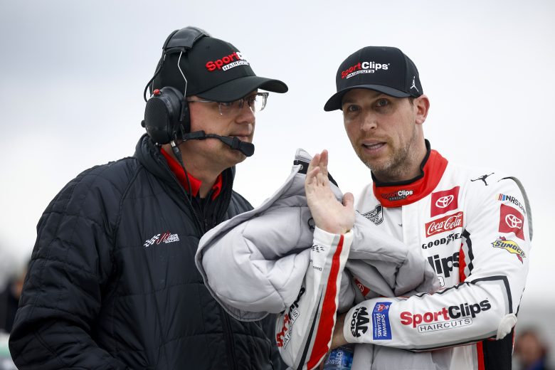 MARTINSVILLE, VIRGINIA - APRIL 08: Denny Hamlin, driver of the #11 Sport Clips Haircuts Toyota, speaks with a crew member during qualifying for the NASCAR Cup Series Blue-Emu Maximum Pain Relief 400 at Martinsville Speedway on April 08, 2022 in Martinsville, Virginia. (Photo by Jared C. Tilton/Getty Images) | Getty Images