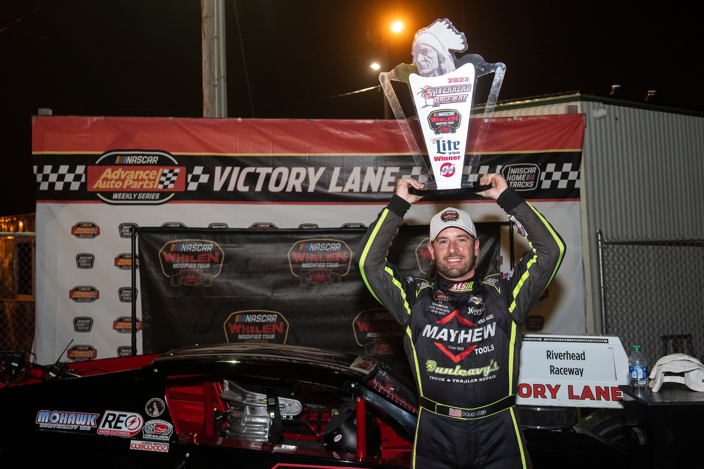 Doug Coby, driver of the #7 John Blewitt Inc, hoists his trophy in Victory Lane during the Miller Lite 200 for the Whelen Modified Tour at Riverhead Raceway on May 14, 2022 in Riverhead, New York. (Mike Lawrence/NASCAR)