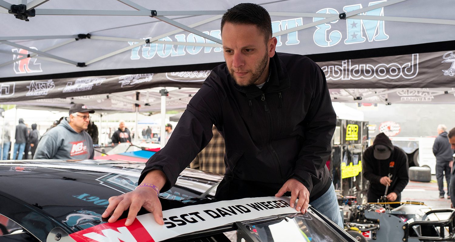 Justin Bonsignore, driver of the #51 Phoenix Communications Inc. Chevrolet, helps put a Memorial Day decal on his car prior to the Jennerstown Salutes 150 Presented By DGV for the NASCAR Whelen Modified Tour in Jennerstown, Pennsylvania on May 29, 2021. (Nate Smallwood/NASCAR)