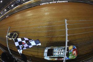 BRISTOL, TENNESSEE - APRIL 17: Kyle Busch, driver of the #18 Mars Crunchy Cookie Toyota, takes the checkered flag ahead of Tyler Reddick, driver of the #8 3CHI Chevrolet, to win the NASCAR Cup Series Food City Dirt Race at Bristol Motor Speedway on April 17, 2022 in Bristol, Tennessee. (Photo by Logan Riely/Getty Images) | Getty Images