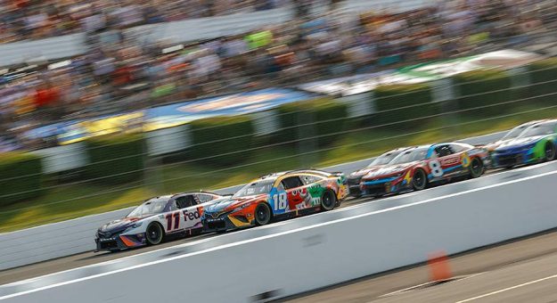 Denny Hamlin (11) leads Kyle Busch (18) and the rest of the field at Pocono Raceway.