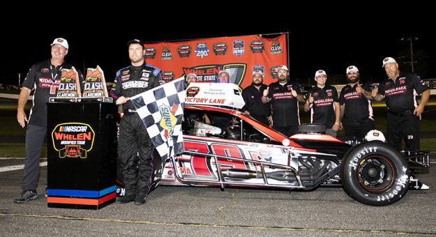 Jon McKennedy, driver of #79 Middlesex Interiors Modified car, poses for a photo with his crew team after winning the Clash at Claremont 150 for the Whelen Modified Tour at Claremont Motorsports Park on July 29, 2022 in Claremont, New Hampshire. (Rachel O'Driscoll/NASCAR)