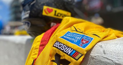 A fire suit and helmet sitting the pit road wall