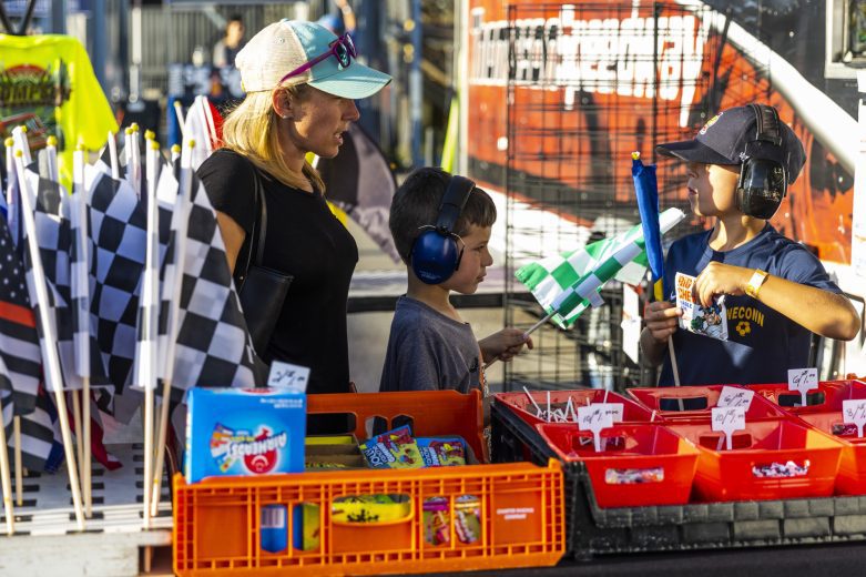 Young fans look at souvenirs during the Phoenix Communications 150 for the Whelen Modified Tour at Thompson Speedway Motorsports Park on August 18, 2022 in Claremont, New Hampshire. (Adam Glanzman/NASCAR)
