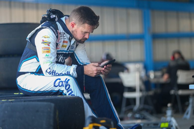 Ricky Stenhouse Jr. checks his phone during a break in Day 1 of the Martinsville Speedway organizational test