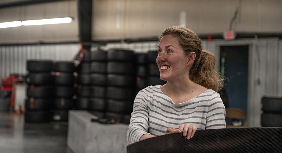 Kolby Garrison smiles alongside the RCR pit-practice car during a visit to the Richard Childress Racing shop