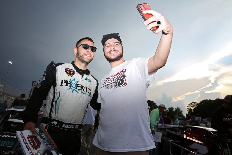 Justin Bonsignore, driver of the #51 Phoenix Communications, Inc. Modified takes a selfie with a fan during the CheckeredFlag.com 150 for the NASCAR Whelen Modified Tour at Larry King Law's Langley Speedway on August 27, 2022 in Hampton, Virginia. (Ryan M. Kelly/NASCAR)