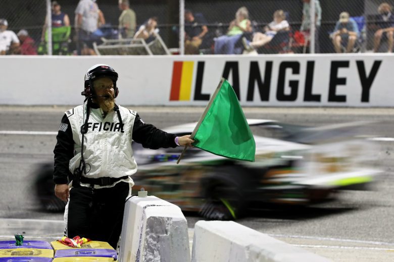 An official waves the green flag during the CheckeredFlag.com 150 for the NASCAR Whelen Modified Tour at Larry King Law's Langley Speedway on August 27, 2022 in Hampton, Virginia. (Ryan M. Kelly/NASCAR)