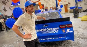 Kyle Larson alongside the No. 5 Chevy on the shop floor of the auto tech department at Hanahan (S.C.) High School