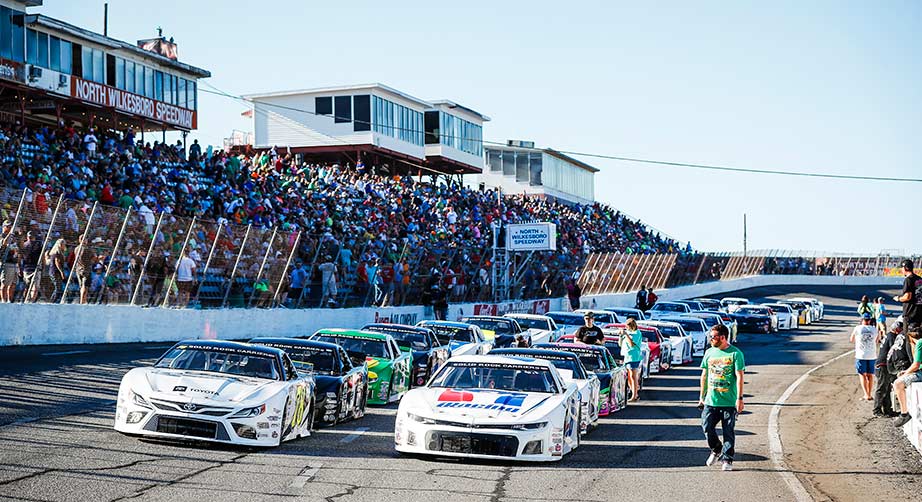 Late Model cars line up in front of a full crowd at North Wilkesboro Speedway