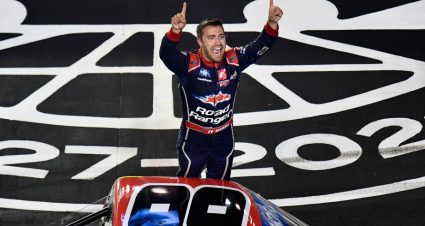 Ty Majeski stands on the door of his truck and points to the crowd in celebration