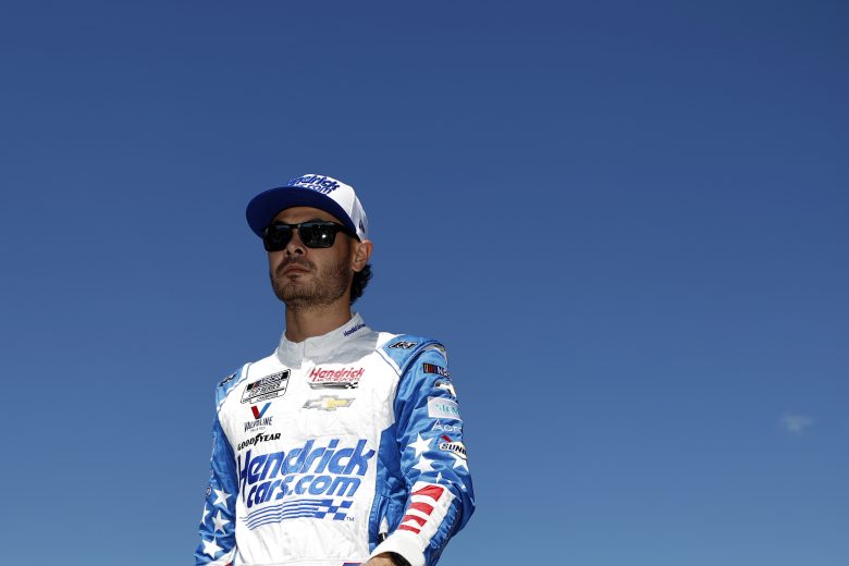 Kyle Larson walks under clear blue skies at Kansas.