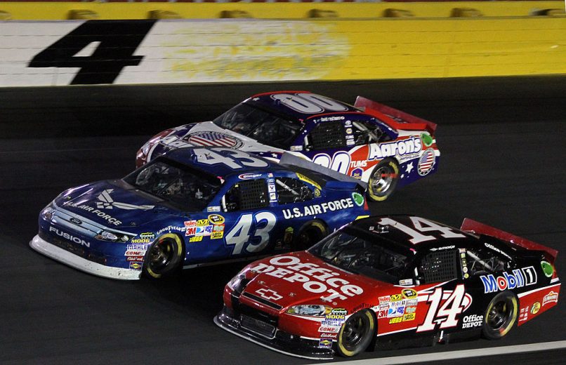 CONCORD, NC - MAY 29: Tony Stewart, driver of the #14 Office Depot / Mobil 1 Chevrolet races with A J Allmendinger, driver of the #43 U.S. Air Force Ford and David Reutimann, driver of the #00 Aaron's Armed Forces Foundation Toyota during the NASCAR Sprint Cup Series Coca-Cola 600 at Charlotte Motor Speedway on May 29, 2011 in Concord, North Carolina. (Photo by Jerry Markland/Getty Images for NASCAR) | Getty Images