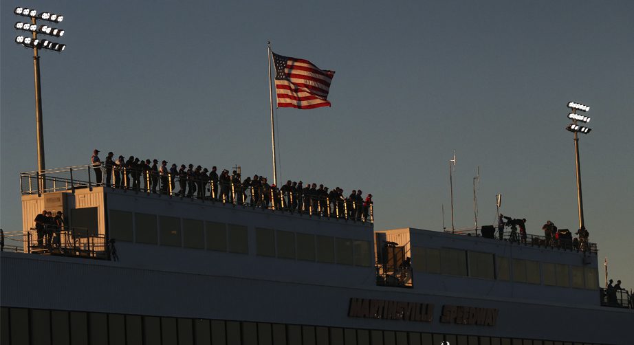 Spotters look down at the track as the sun sets behind them.