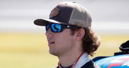 Chase Purdy stands on the grid wearing a baseball cap and sunglasses