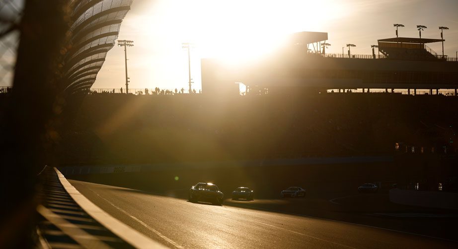NASCAR Cup Series cars race during sunset at Phoenix Raceway