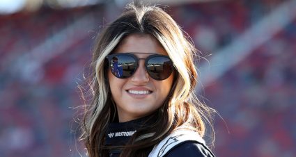 Hailie Deegan wearing sunglasses and smiling at the track