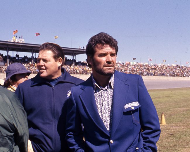DAYTONA BEACH, FL — February 1972: Actor James Garner (R) was Grand Marshall of the Daytona 500 at Daytona International Speedway. Garner, who did a bit of racing himself, entered cars at Daytona for the 24 Hours of Daytona on occasion. He also starred in the critically acclaimed movie “Grand Prix” in 1966. Just behind Garner is 1963 Daytona 500 winner DeWayne “Tiny” Lund. (Photo by ISC Images & Archives via Getty Images)