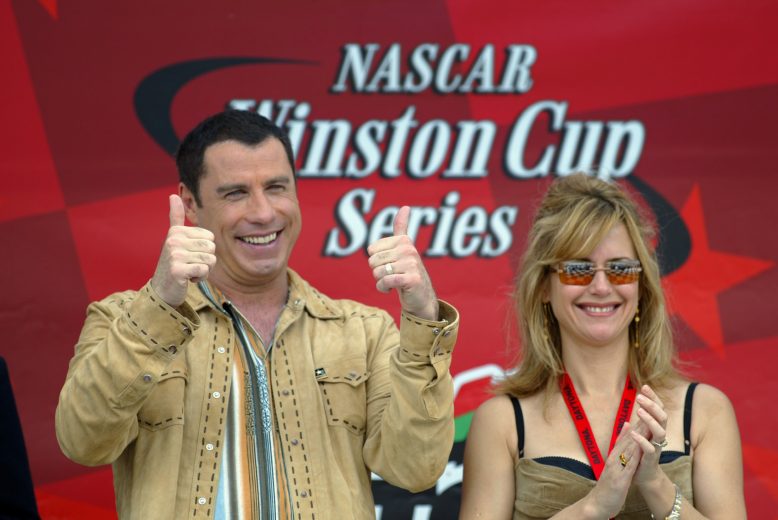 DAYTONA, FL - FEBRUARY 16: John Travolta with his wife Kelly Preston during the NASCAR Winston Cup Daytona 500 on February 16, 2003 at the Daytona International Speedway in Daytona, Florida. (Photo by Jamie Squire/Getty Images).