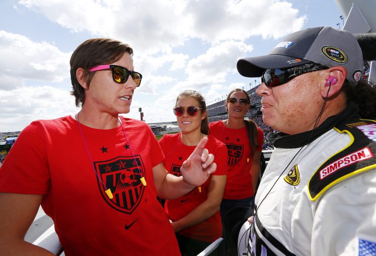 DAYTONA BEACH, FL - FEBRUARY 22: U.S. National Women's Soccer Team members Abby Wambach, Kelley O'Hara and Christie Rampone recieve instructions from NASCAR starter Kim Lopez for waving the green flag to start the NASCAR Sprint Cup Series 57th Annual Daytona 500 at Daytona International Speedway on February 22, 2015 in Daytona Beach, Florida. (Photo by Jonathan Ferrey/NASCAR via Getty Images)