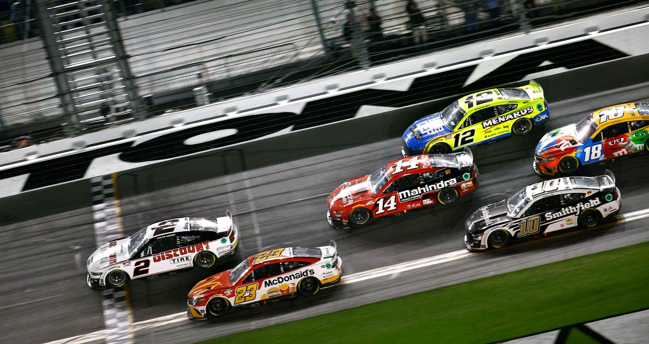 Austin Cindric, in the No. 2 Team Penske Ford (left, white), holds off the rest of the NASCAR Cup Series field in the 2022 Daytona 500 at Daytona International Speedway.