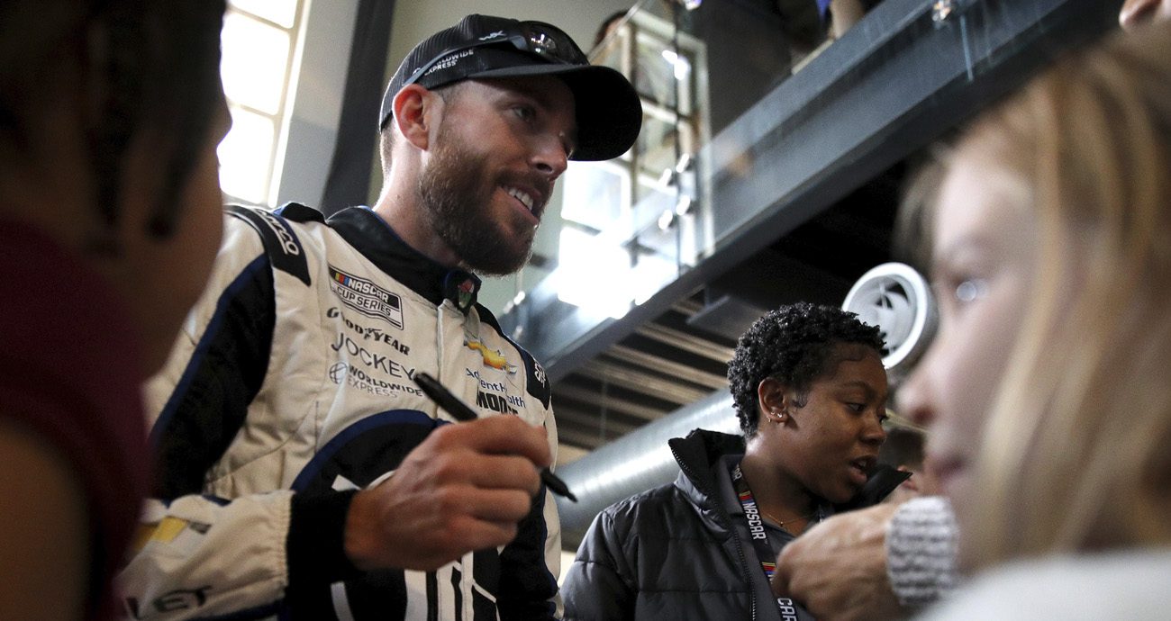 Ross Chastain signs autographs for fans.