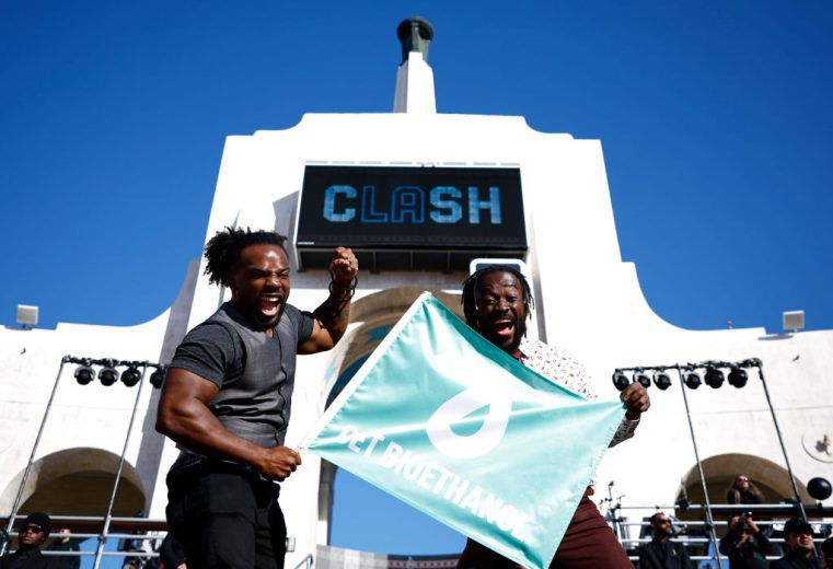WWE Wrestlers Kofi Kingston and Xavier Woods wave the green flag
