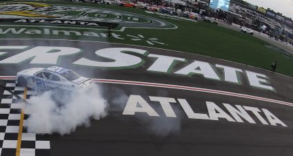 Austin Hill does a burnout in his car, creating a white cloud of smoke.