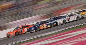 Brad Keselowski (6) races alongside Joey Logano at the front of the pack at Atlanta Motor Speedway